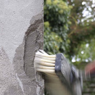 Ødelagt hjørne på pusset murvegg: Påfør rikelig med vann på området som skal repareres Ødelagt hjørne på pusset murvegg: Påfør rikelig med vann på området som skal repareres